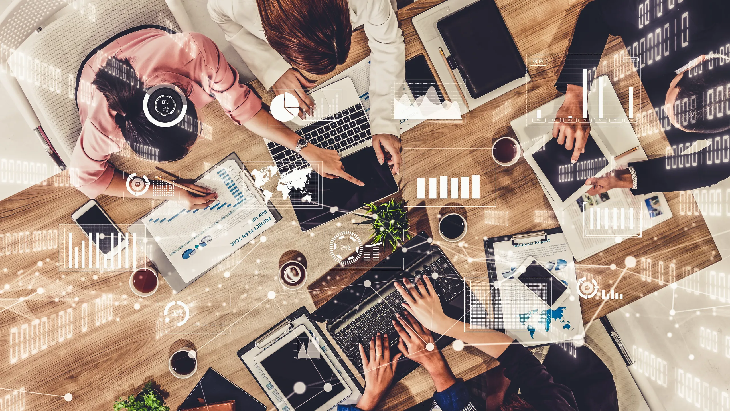 Widoczne z góry spotkanie biznesowe czwórki osób, omawiających dane analityczne